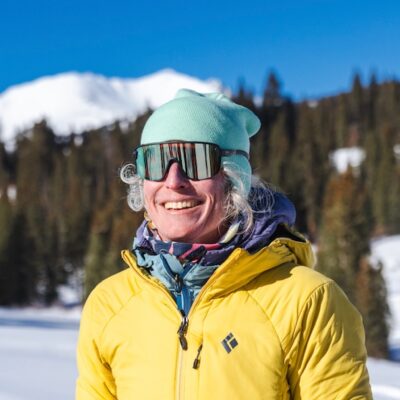 AAI Instructor Katie Koons, Smiles infront of an alpine winter background.